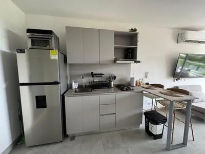 a kitchen with a refrigerator and a table in it at Apartamento cerca al mar santa Marta- santamarina-614 in Santa Marta