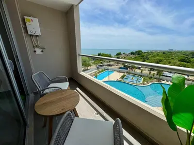 a balcony with a table and chairs and a view of a pool at Apartamento cerca al mar santa Marta- santamarina-614 in Santa Marta