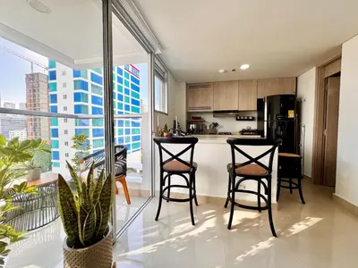 a kitchen with bar stools and a kitchen with a view at Stunning Bocagrande Beach Apartment in Cartagena de Indias