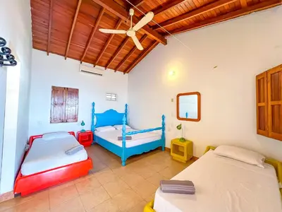 a bedroom with two beds and a ceiling fan at Casa San Miguel Tolú, Playa El Francés in San Silvestre