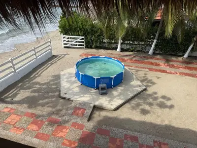 a small swimming pool on a platform next to the beach at Casa San Miguel Tolú, Playa El Francés in San Silvestre