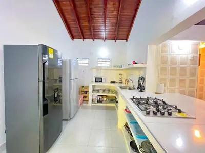 a kitchen with a stove and a refrigerator at Casa San Miguel Tolú, Playa El Francés in San Silvestre