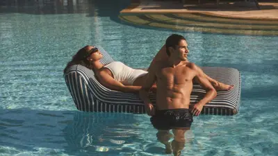 a man and woman in the water in a swimming pool at Four Seasons Hotel & Residences Cartagena in Cartagena de Indias