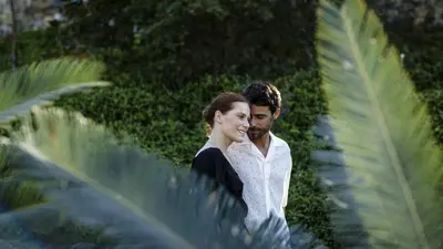 a bride and groom standing next to a palm tree at Four Seasons Hotel & Residences Cartagena in Cartagena de Indias