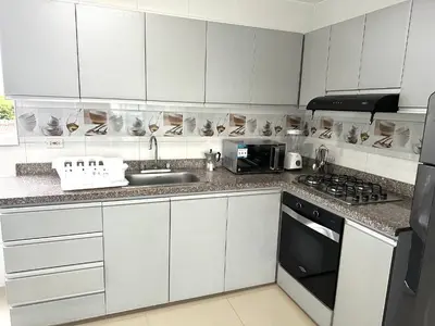 a kitchen with white cabinets and a sink at Dubai 202 in Barranquilla