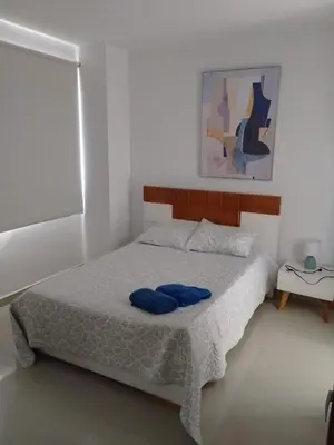 a bedroom with a bed with blue pillows on it at Bijao 4a in Barranquilla