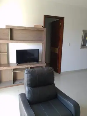 a black leather chair in a living room with a television at Bijao 4a in Barranquilla