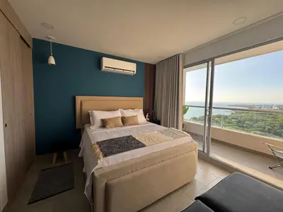 a bedroom with a large bed and a large window at Apartamento de Lujo en Santa Marta con vista al mar -Santamarina- 1802 in Santa Marta