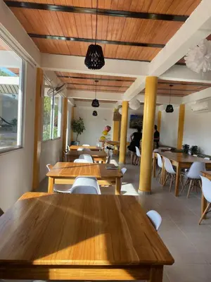a dining room with wooden tables and chairs at Casa Mariana Hostel Boutique in Santa Marta