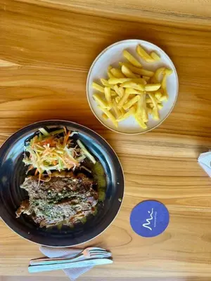 a table with a plate of food and a bowl of fries at Casa Mariana Hostel Boutique in Santa Marta