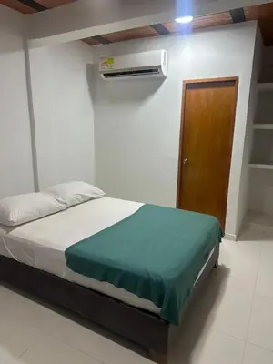 a bedroom with a bed and a wooden door at Casa Mariana Hostel Boutique in Santa Marta