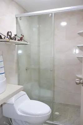 a bathroom with a toilet and a glass shower at Apartamento primer piso Olamar Coveñas in Coveñas