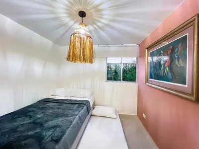 a room with a bed and a chandelier at Apartamento primer piso Olamar Coveñas in Coveñas