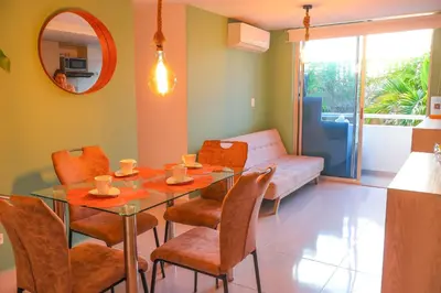 a dining room with a table and chairs and a couch at Apartamento primer piso Olamar Coveñas in Coveñas