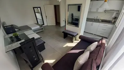 a living room with a couch and a kitchen at Apartamento Cerca a la playa, Piscina, Wifi, AC in Cartagena de Indias