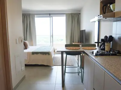 a bedroom with a bed and a kitchen with a table at Santa Marta apartamento frente al mar -Santamarina- 1202 in Santa Marta