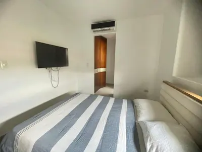 a bedroom with a bed and a tv on the wall at Bijao 6b in Barranquilla