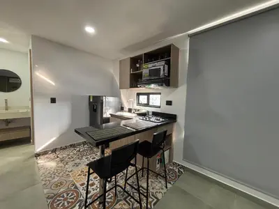 a kitchen with a counter and stools in a room at Coral Tower 603 in Barranquilla