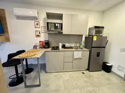 a small kitchen with a table and a refrigerator at Apartamento con vistas al mar-SantaMarina-1303 in Santa Marta