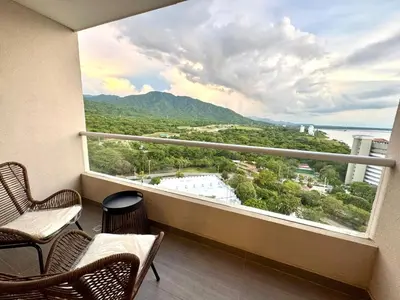 a balcony with two chairs and a large window at Apartamento con vistas al mar-SantaMarina-1303 in Santa Marta