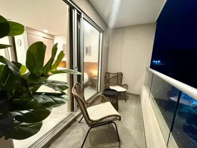 a balcony with two chairs and a plant at Apartamento con vista,piscina y playa -SantaMarina-803 in Santa Marta