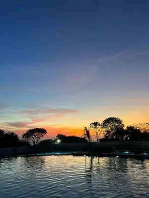 a large pool of water with a sunset in the background at Apartamento con vista,piscina y playa -SantaMarina-803 in Santa Marta