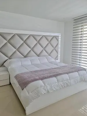 a white bedroom with a large white bed with a large headboard at Morros Eco in Cartagena de Indias