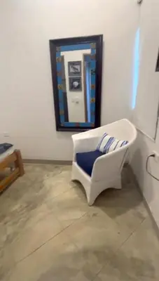 a white chair sitting in front of a mirror at Apartaestudio Terraza del Sol 101 in Coveñas