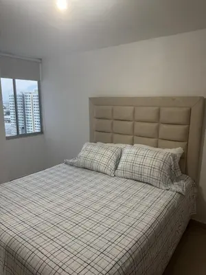 a bedroom with a bed with a checkered blanket and a window at Apartamento moderno con una increíble vista en zona exclusiva de la ciudad de Barranquilla in Barranquilla