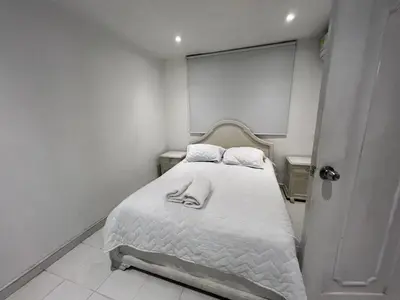 a white bedroom with a bed with white sheets at Edificio Quintero in Barranquilla