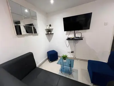 a living room with a couch and a tv on the wall at Edificio Quintero in Barranquilla