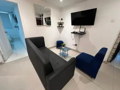 a living room with a couch and a flat screen tv at Edificio Quintero in Barranquilla