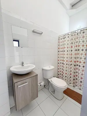 a white bathroom with a toilet and a sink at Casa 1811 in Cartagena de Indias