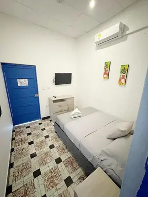 a bedroom with a bed and a blue door at Casa 1811 in Cartagena de Indias