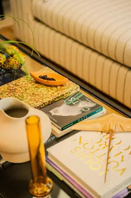 a table with books and a cup of coffee on it at Apt-Casa Marina Cruz Bay View-10 mins walk Oldtown in Cartagena de Indias