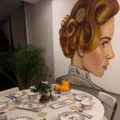 a painting of a woman sitting at a table at Apt 3 Bedrooms SeaView AC Buenavista in Puerto Colombia