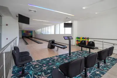 a bowling alley with chairs and a table in a room at Apt 3 Bedrooms SeaView AC Buenavista in Puerto Colombia