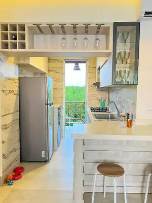 a kitchen with a refrigerator and a counter with chairs at Apartamento frente al mar in San Silvestre