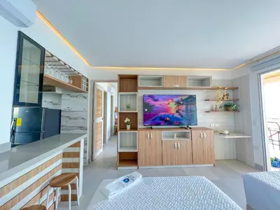 a small living room with a television and a kitchen at Apartamento frente al mar in San Silvestre
