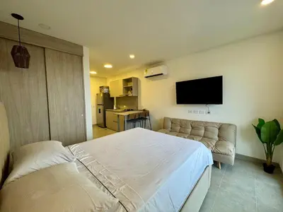 a bedroom with a bed and a couch and a flat screen tv at Apartamento cerca del mar- SantaMarina-604 in Santa Marta