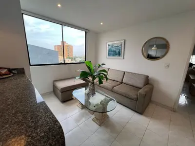 a living room with a couch and a glass table at Vistas del Mar in Barranquilla