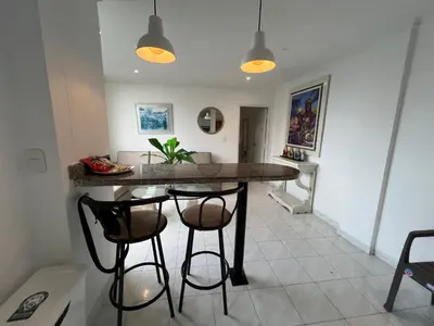 a kitchen with a table and two bar stools at Vistas del Mar in Barranquilla