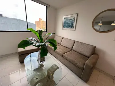 a living room with a couch and a glass table at Vistas del Mar in Barranquilla