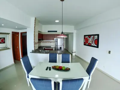 a kitchen and dining room with a white table and chairs at Big in Cartagena de Indias