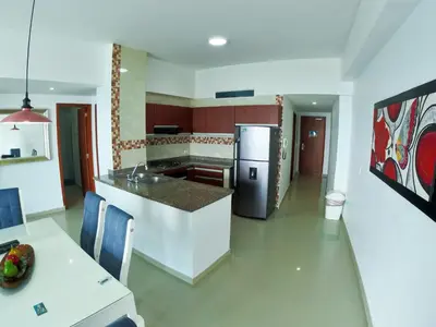 a kitchen with a counter and a refrigerator and a table at Big in Cartagena de Indias
