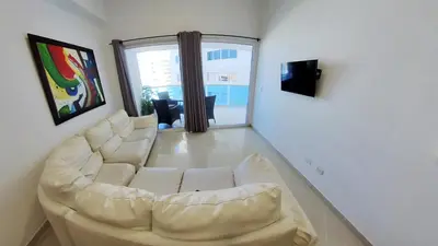 a living room with a white couch and a television at Big in Cartagena de Indias