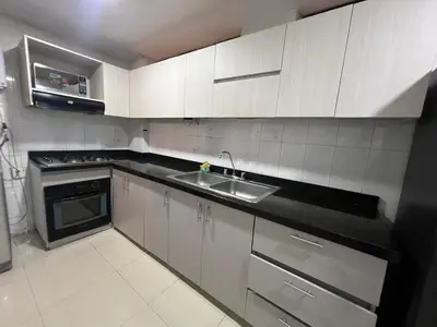 a kitchen with white cabinets and a sink and a stove at Riomar in Barranquilla