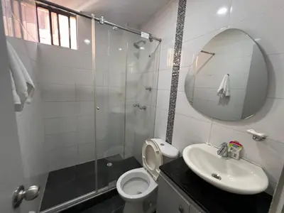 a bathroom with a toilet and a sink and a mirror at Riomar in Barranquilla