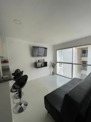 a bedroom with a bed and a chair and a television at Apto Amplio con Piscina 3 Hab a Pasos del Mar in Cartagena de Indias