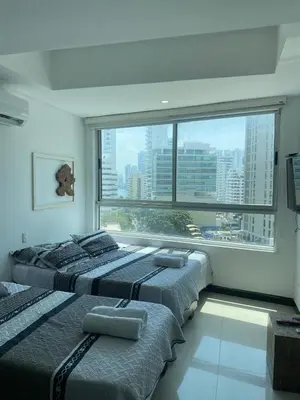 two beds in a room with a large window at Eliptic Cartagena-Oceano in Cartagena de Indias